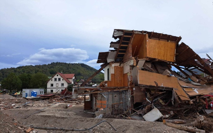Zniszczony budynek po katastrofie, z widocznymi zniszczeniami i zniszczoną okolicą.