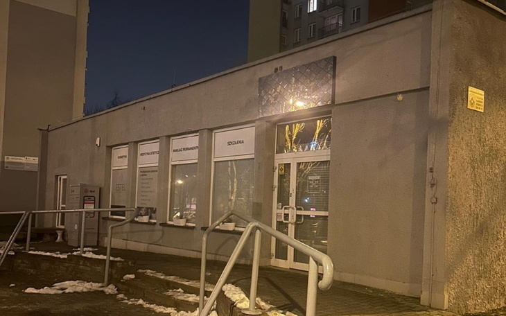 Budynek w nocy z oświetleniem, z widocznymi oknami i drzwiami.