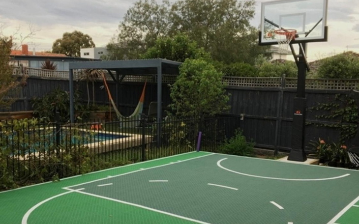 Boisko do koszykówki z widokiem na basen i huśtawkę.