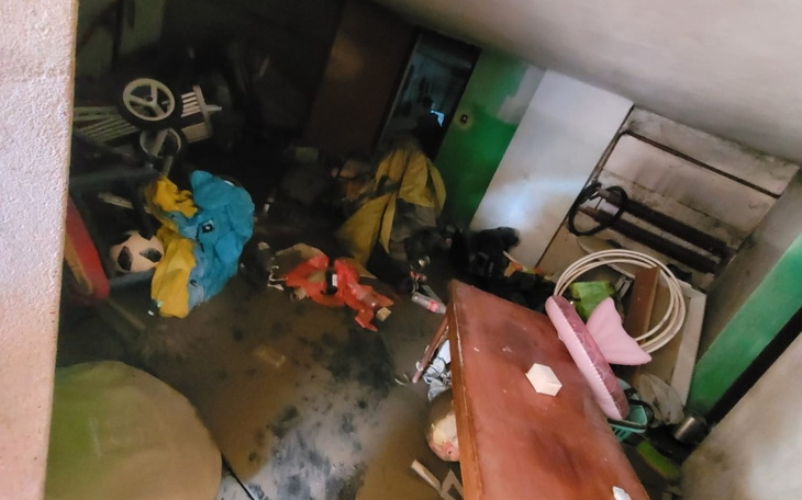 Zabałaganione pomieszczenie z różnymi przedmiotami i odzieżą na podłodze.