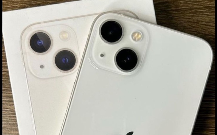 Dwa aparaty iPhone 13 na tle białego pudełka.