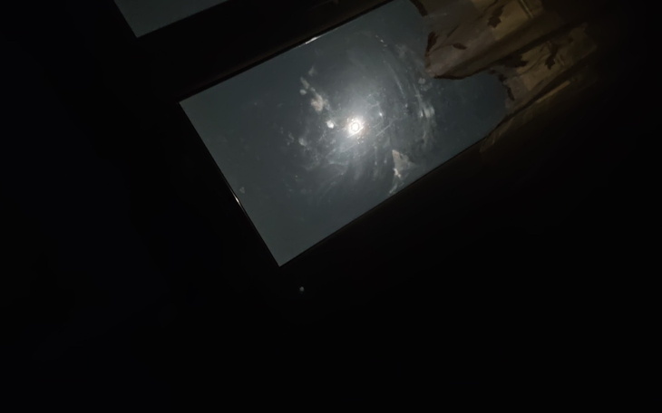 Księżyc odbijający się w oknie, nocna sceneria.