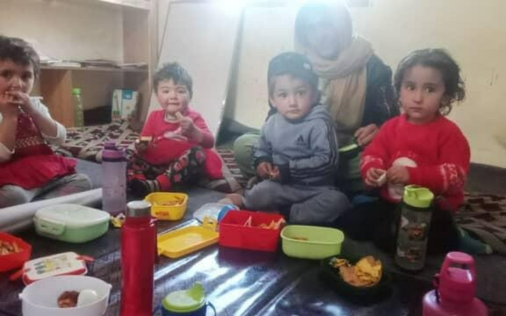 Dzieci jedzące posiłek w przytulnym pomieszczeniu.