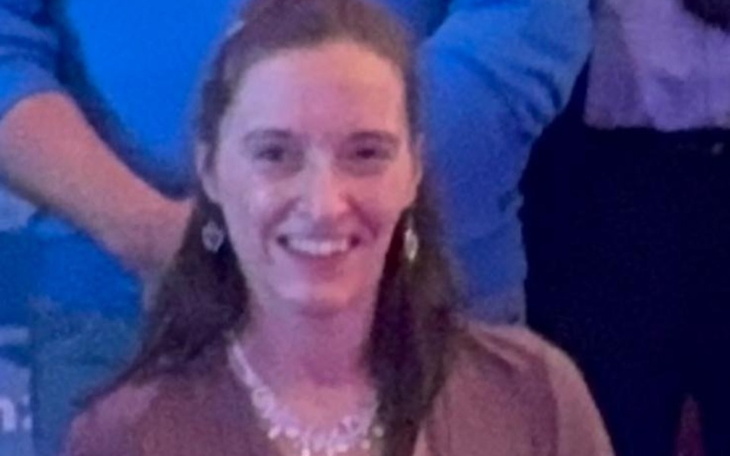 Uśmiechnięta kobieta w eleganckim stroju na wydarzeniu.