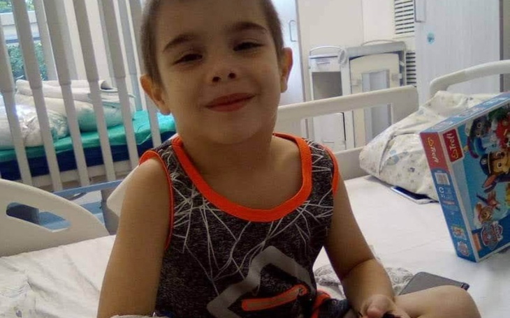 Uśmiechnięty chłopiec w szpitalu, trzymający zabawkę.