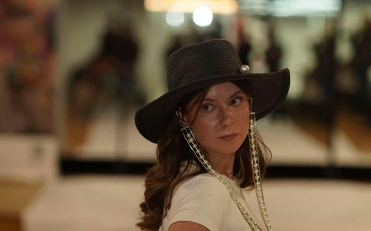 Modelka w kapeluszu, pozująca na tle luster.
