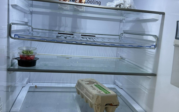 Pusta lodówka z kilkoma produktami na półkach.