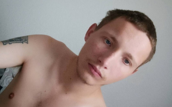 Mężczyzna w półnagim stanie, z zamyślonym wyrazem twarzy.