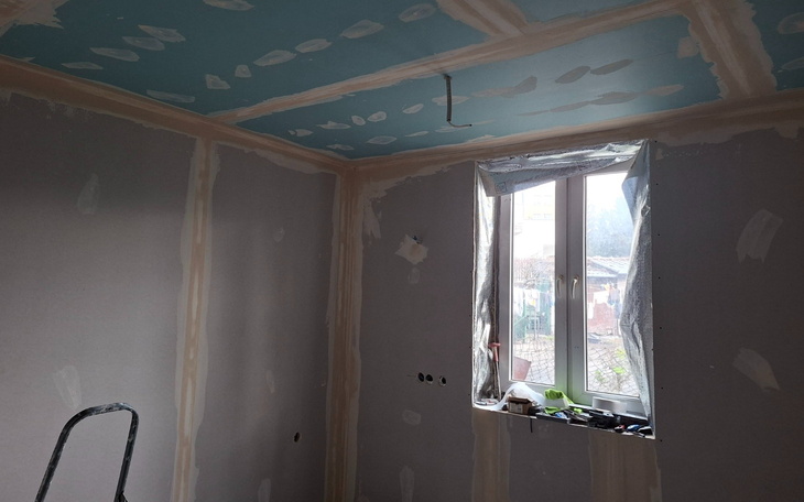 Pokój w trakcie remontu, z nowym sufitem i oknem.