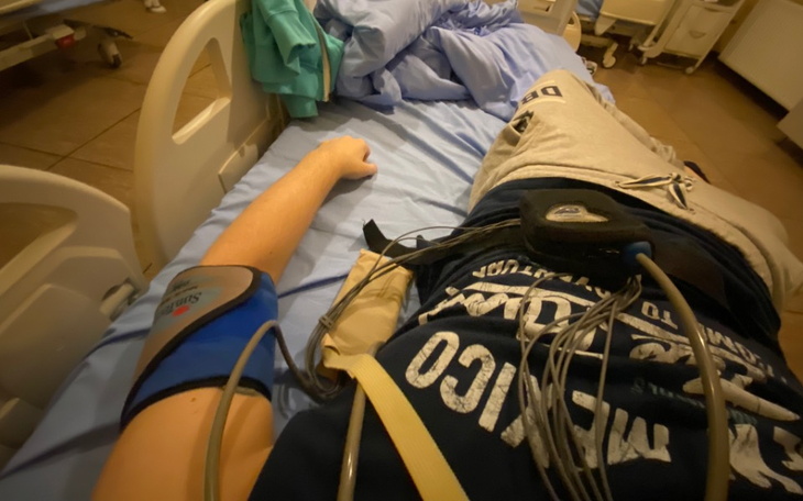 Osoba leżąca na łóżku szpitalnym, monitorowanie zdrowia.