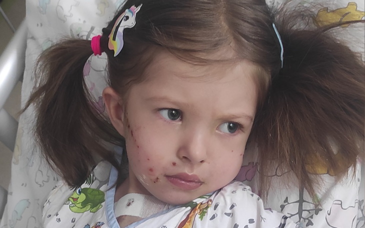 Dziewczynka w szpitalu, z wyrazem smutku na twarzy.