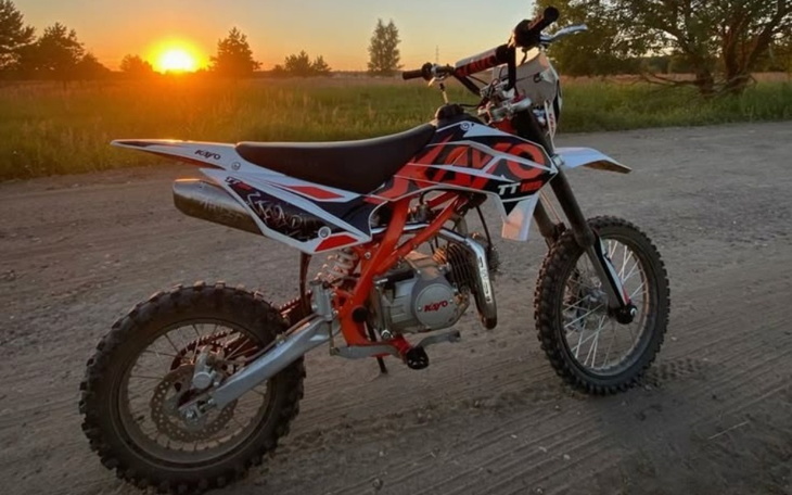 Motocykl terenowy na tle zachodzącego słońca.