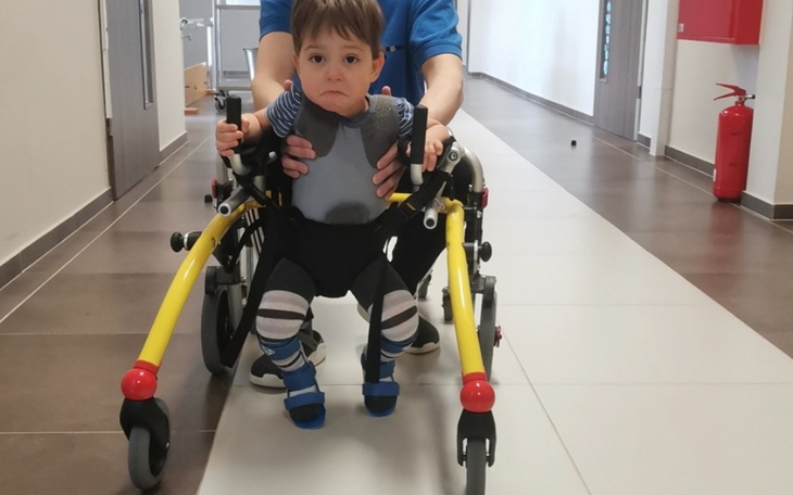 Chłopiec w wózku, korzystający z pomocy w rehabilitacji.