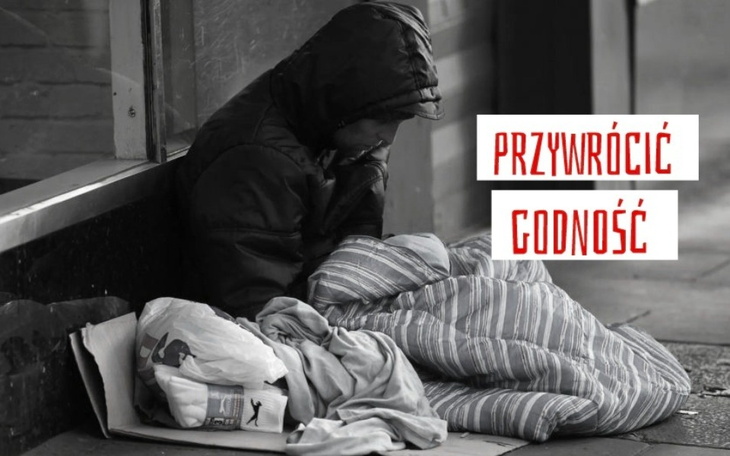 Bezdomny mężczyzna siedzący na ulicy z kocem.