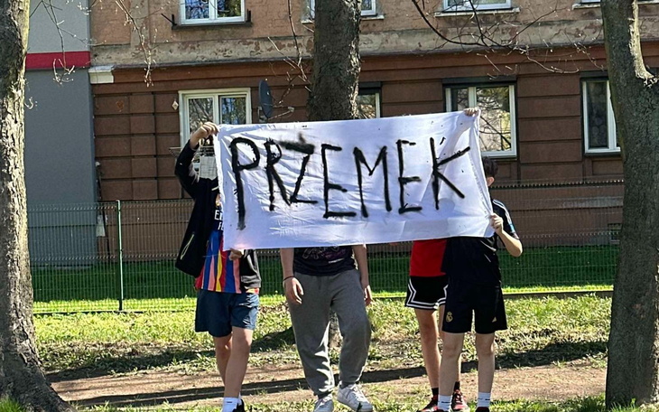 Młodzież trzymająca transparent z napisem 'PRZEMEK'.