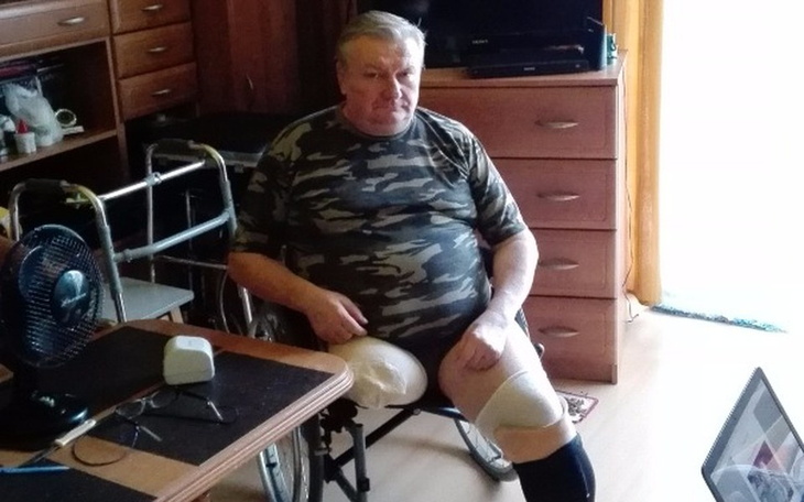 Mężczyzna w kamuflażu siedzący na wózku inwalidzkim.