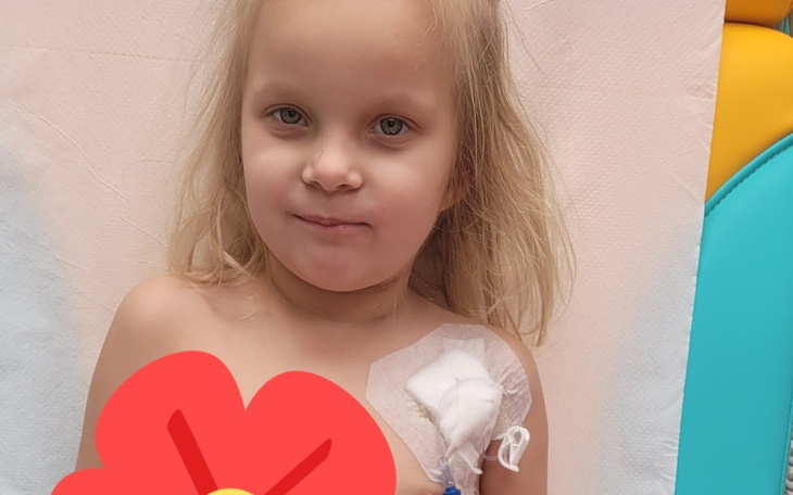 Mała dziewczynka w szpitalu, z opatrunkiem na ramieniu.