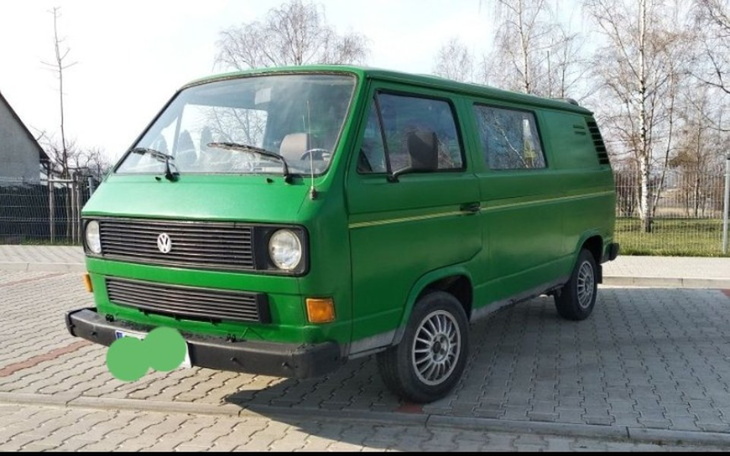 Zielony Volkswagen Transporter zaparkowany na placu.