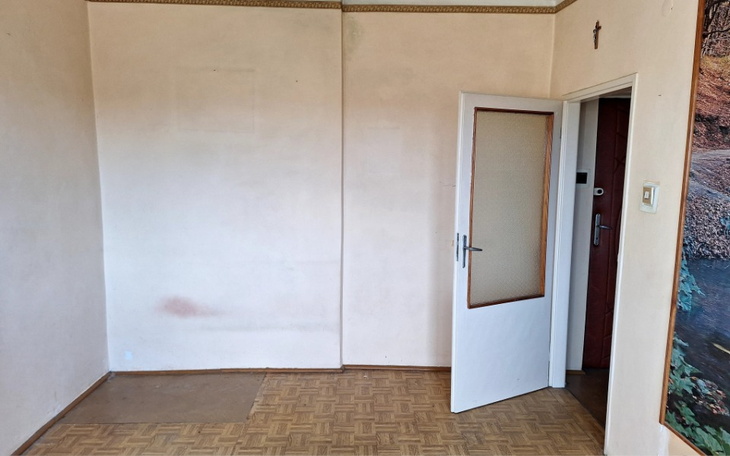 Trójka dzieci w trawie, uśmiechnięte i trzymające kwiaty.