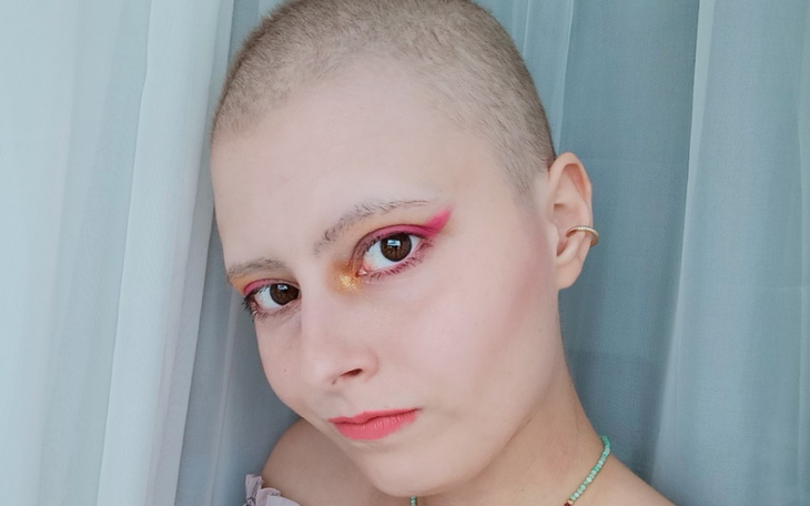 Młoda kobieta z krótkimi włosami, makijaż w intensywnych kolorach.