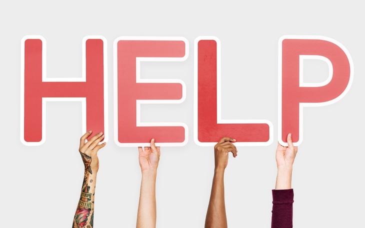 Ręce trzymające duże litery 'HELP', wzywające pomocy.