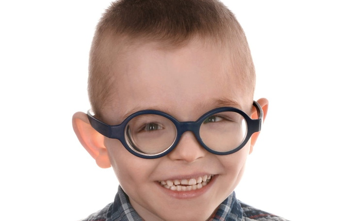 Chłopiec w okularach, uśmiechający się szeroko.