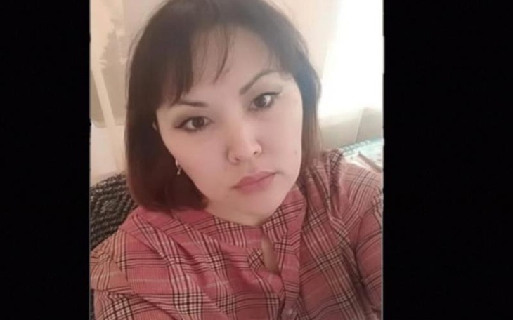 Portret kobiety w czerwonej koszuli, z wyrazem powagi na twarzy.