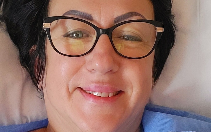 Uśmiechnięta kobieta w okularach.