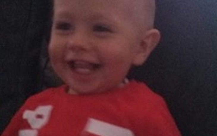 Mały chłopiec w czerwonej koszulce, uśmiechający się.