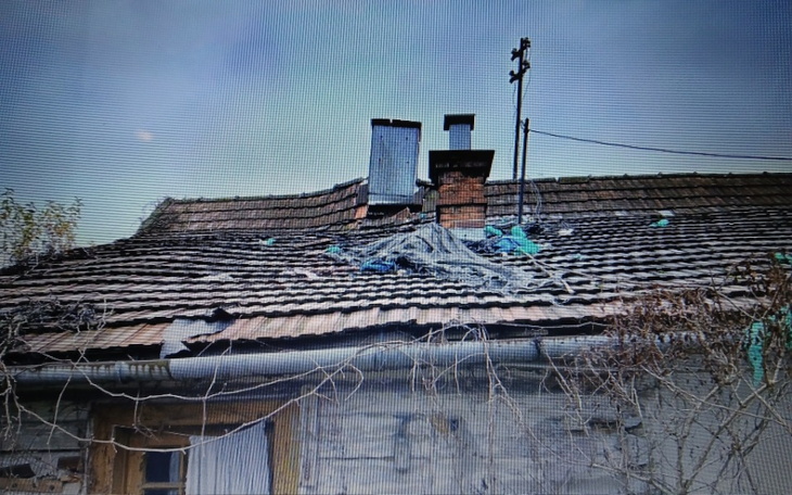 Zniszczony dach domu z widocznymi uszkodzeniami.