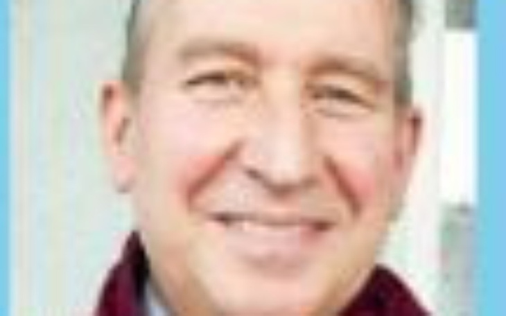 Uśmiechnięty mężczyzna w czerwonym szaliku.