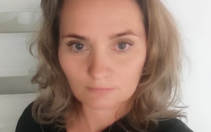 Portret kobiety z długimi włosami, patrzącej w kamerę.