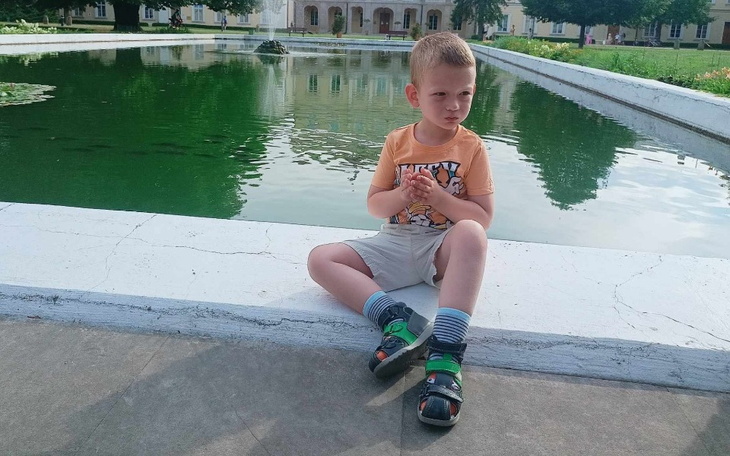 Chłopiec siedzący na brzegu fontanny.