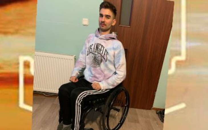 Młody mężczyzna na wózku inwalidzkim, w sportowym stroju.