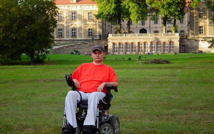 Mężczyzna na wózku inwalidzkim w parku.