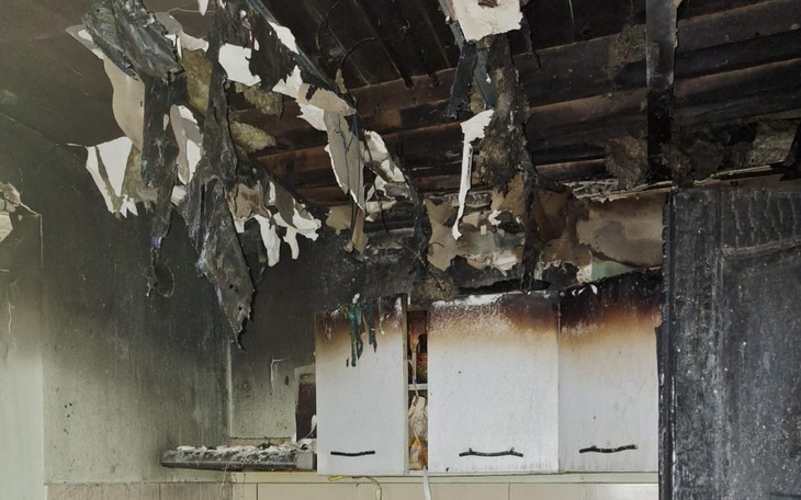 Zniszczona kuchnia po pożarze, z uszkodzonym sufitem.