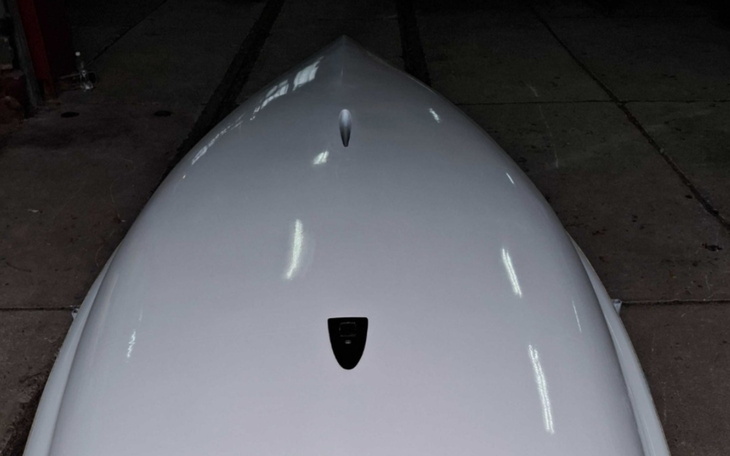 Widok na górną część białej łodzi, w garażu.