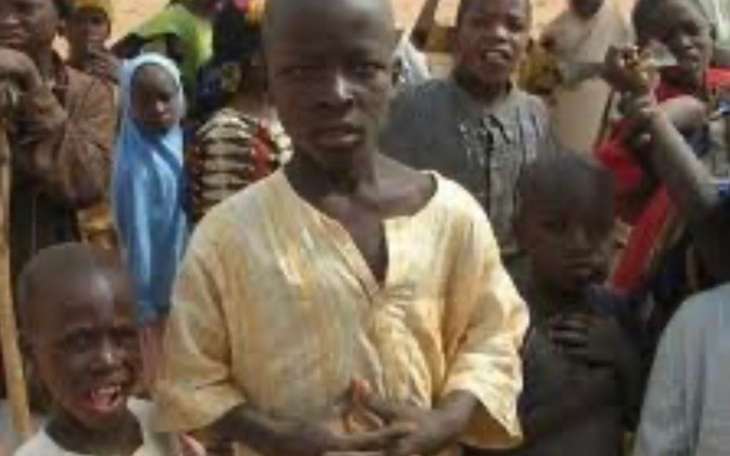 Grupa dzieci w tradycyjnych strojach, pozująca do zdjęcia.