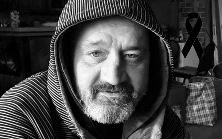 Mężczyzna w kapturze, z brodą, w czarno-białym ujęciu.