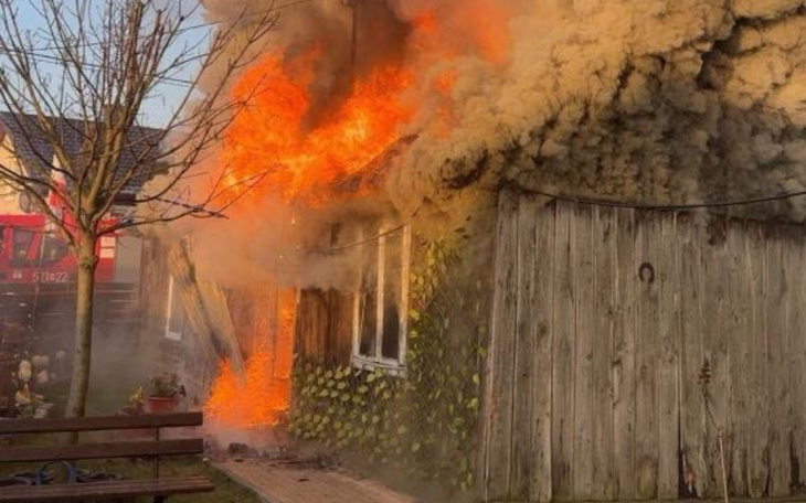 Pożar w budynku, ogień i dym wydobywają się z okien.