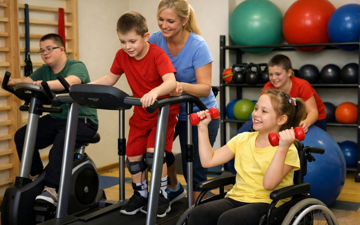 Dzieci ćwiczące na sprzęcie sportowym pod okiem trenera.