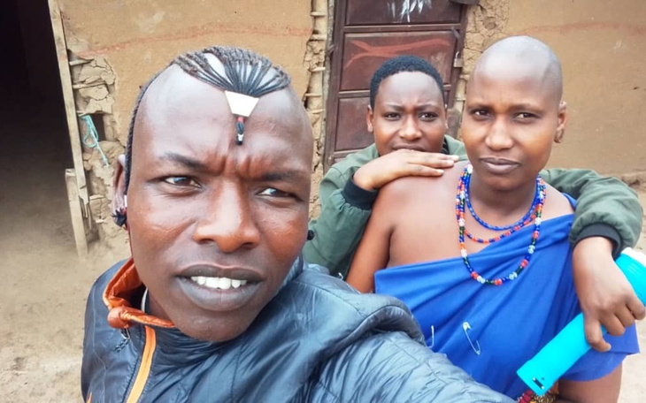 Trzy osoby pozujące do selfie w tradycyjnych strojach.