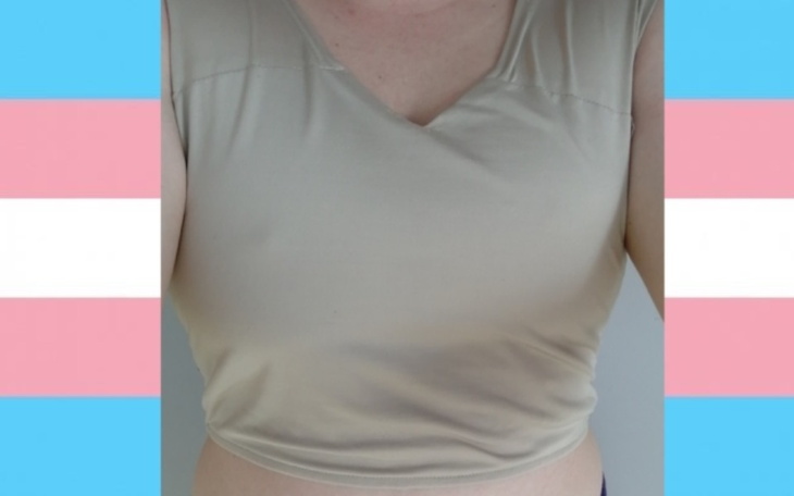 Beżowy top na tle flagi transpłciowej.