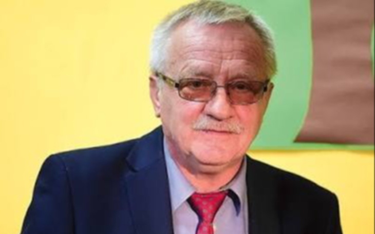 Szary budynek mieszkalny z psem w kadrze w środku domu.