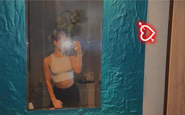 Młoda kobieta robiąca selfie w lustrze, w stylowym otoczeniu.