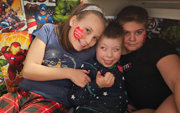 Trójka dzieci bawiących się w przytulnym miejscu.