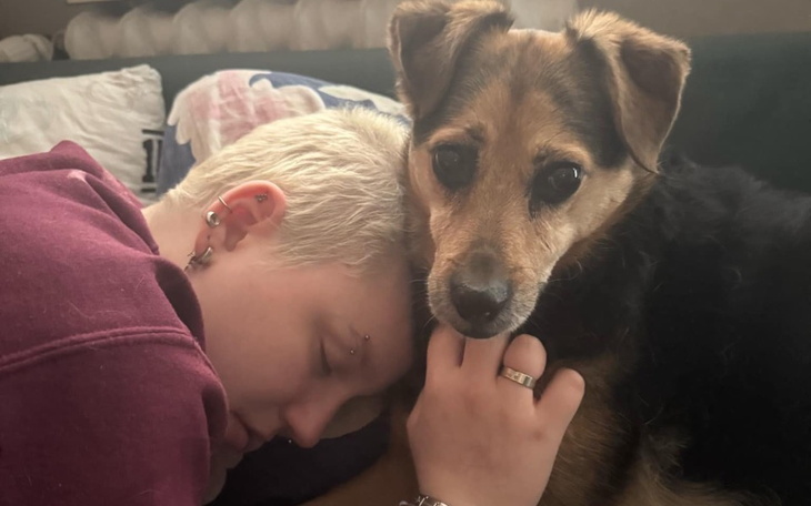 Osoba śpiąca z psem, chwila bliskości i spokoju.