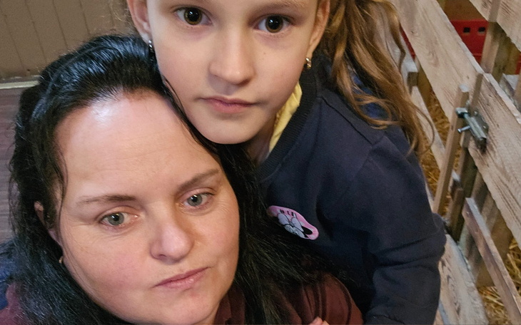 Mama z córką, obie z poważnymi minami w stajni.