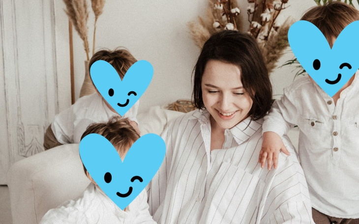 Mama z dziećmi w przytulnym wnętrzu, wszyscy uśmiechnięci.