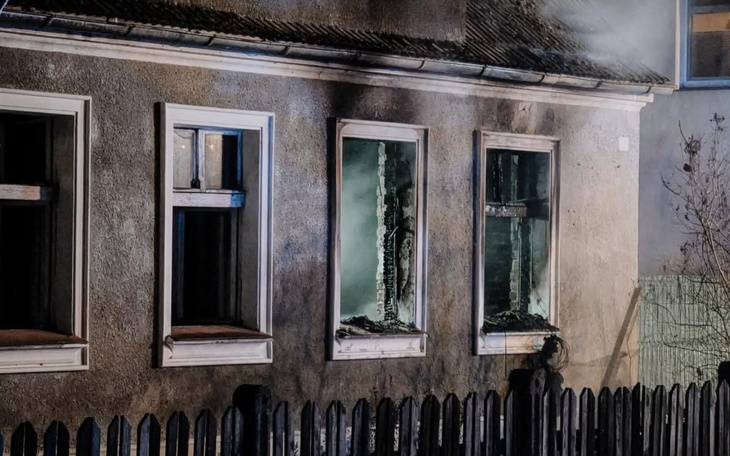 Zniszczony dom po pożarze, z oknami bez szyb.